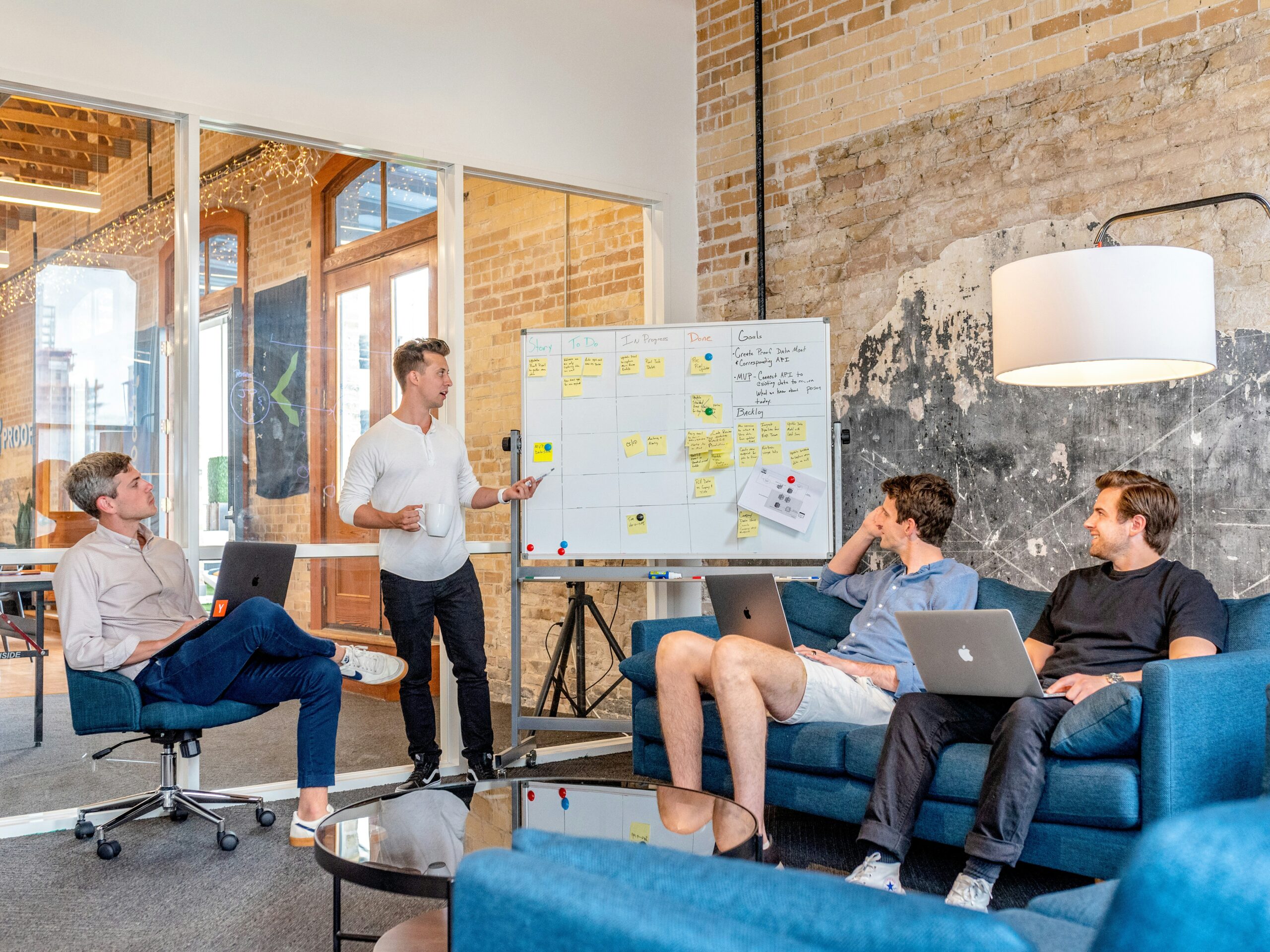 Man presenting on a white board in front of his coworkers.